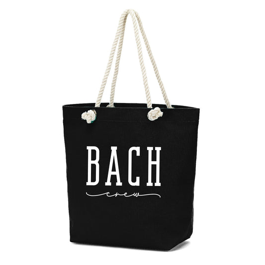 Black tote bag with 'BACH crew' text and rope handles on a white background. Inside zipper pocket. bagNook.com