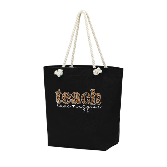 Black tote bag with 'teach like no one is watching' text and rope handles on a white background. Inside zipper! bagNook.com